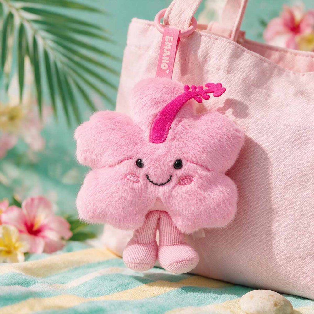 Porte-clé peluche Hibi EMANO en forme d’hibiscus rose accroché à un sac